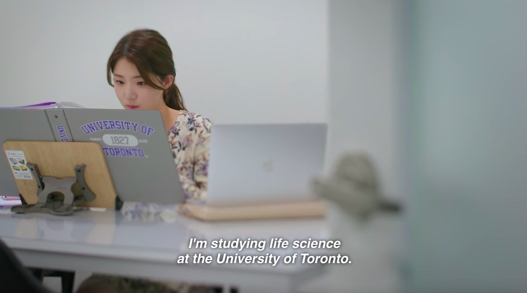 Ji-yeon sits at a desk studying with her hair tied back
