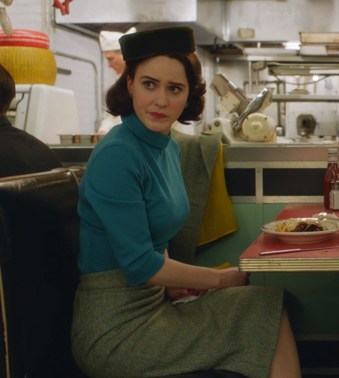 Screenshot from Mrs. Maisel shows Midge sitting at a diner