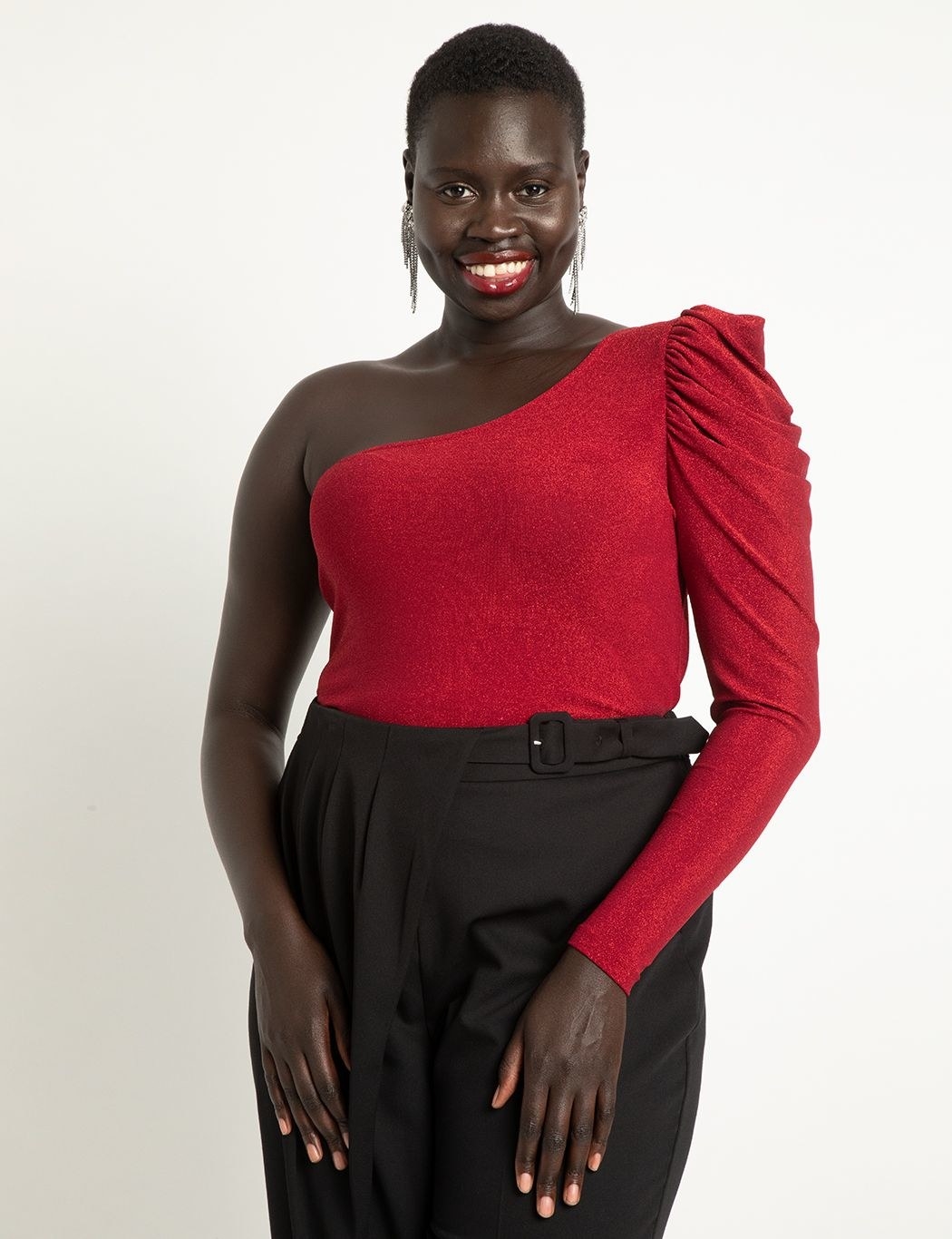 Model wearing red one-shoulder blouse