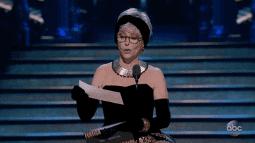 Rita Moreno reads a name on a card at the Oscars and cheers excitedly