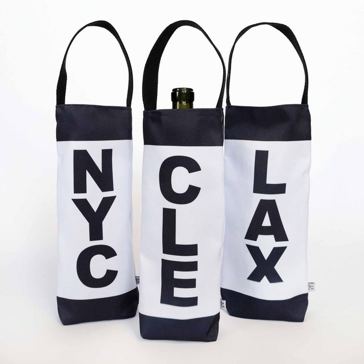 three black and white wine totes printed with "NYC, "CLE", and "LAX"
