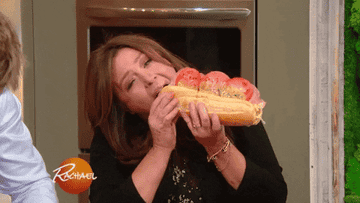 Rachel Ray biting into a large sandwich