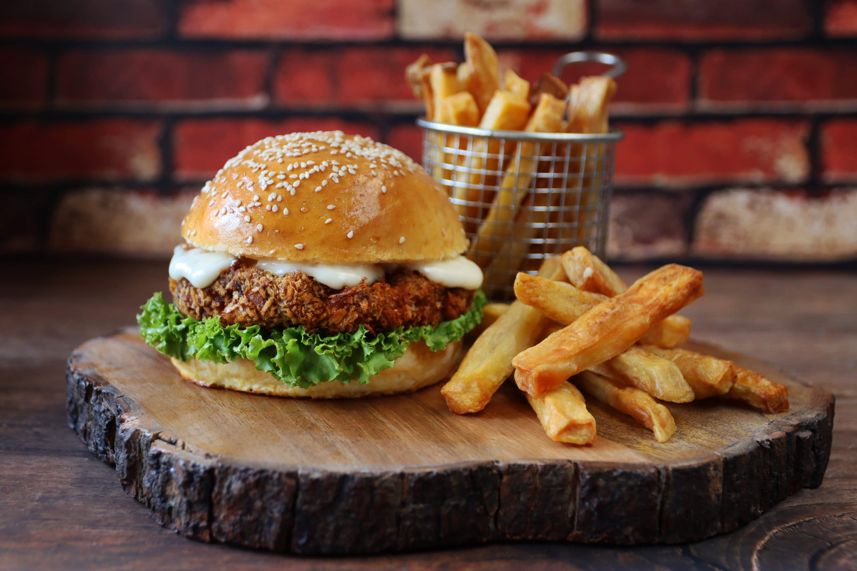 Burger and fries on an ornate wooden serving board