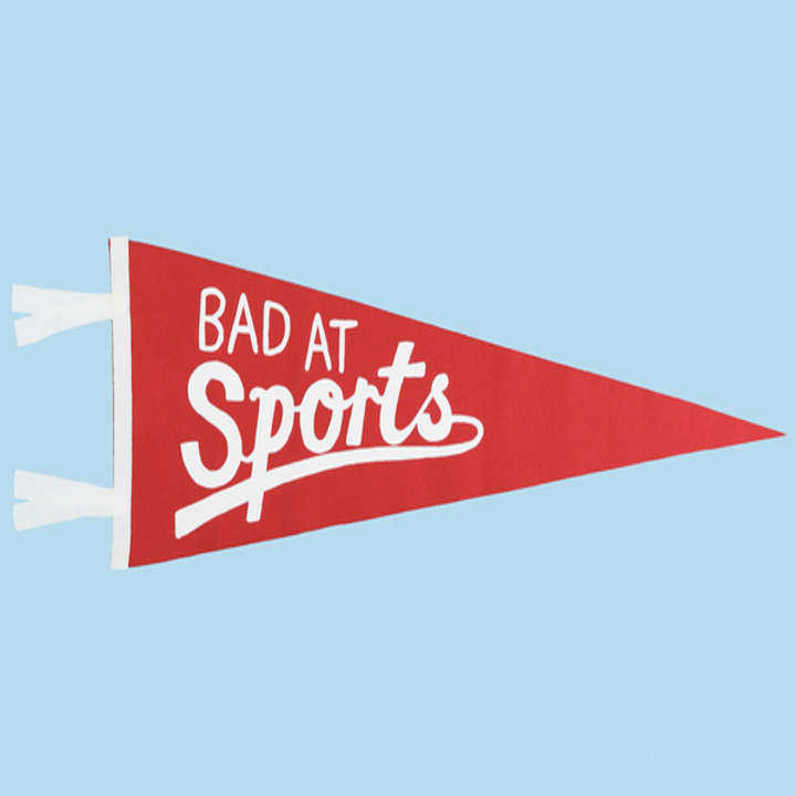 a red pennant flag that says "bad at sports" in white letters