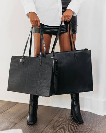 model holding black tote bags