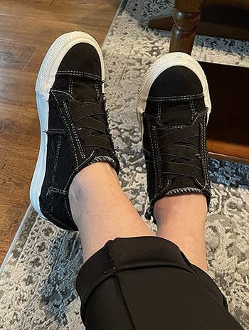 Reviewer wearing black sneakers
