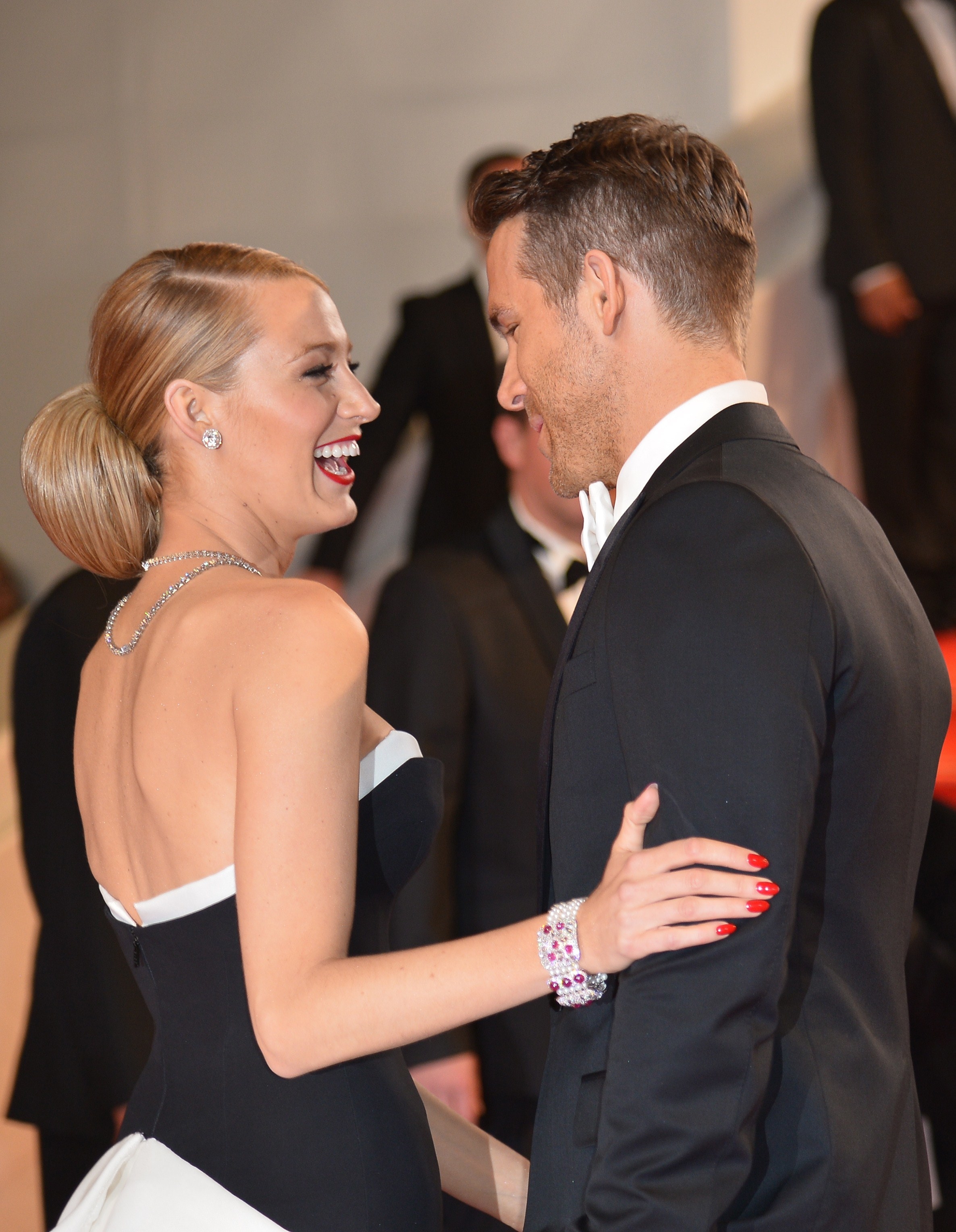 Blake Lively talking to Ryan Reynolds with her hand on his arm