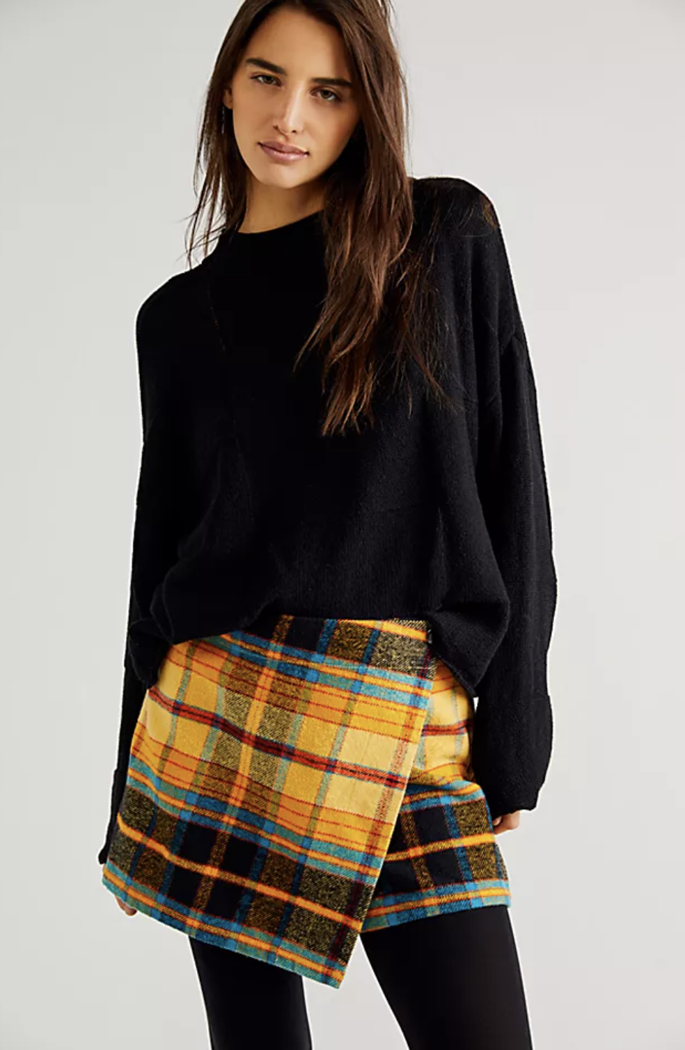 An image of a model wearing a plaid mini skort with tights