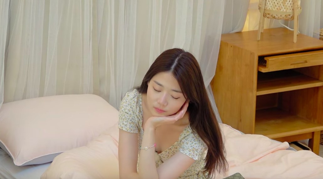 Ji-yeon looks upset, cradling her head in her hand