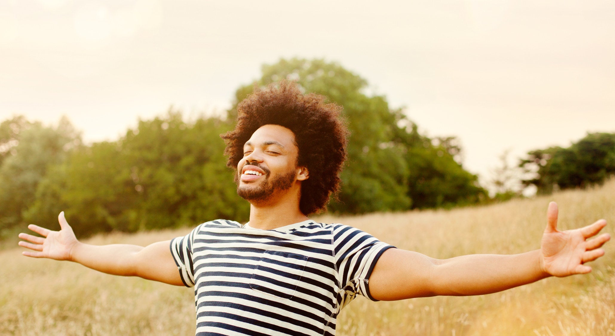 Young man with outstretched hands in field