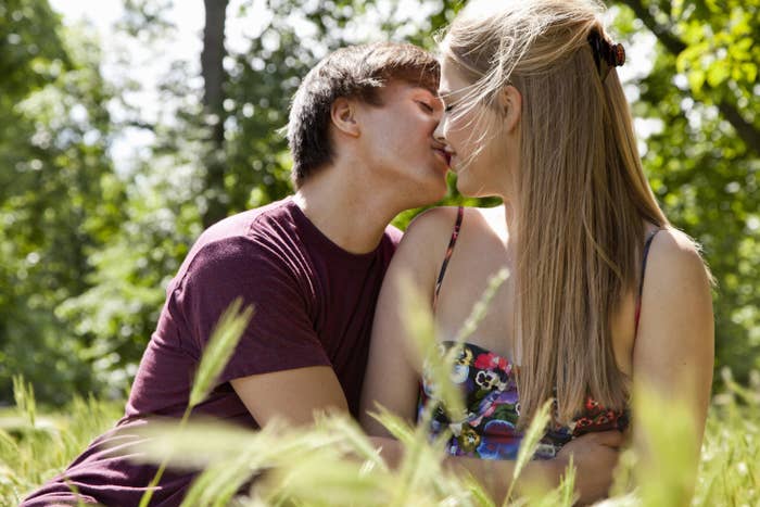 A young couple kissing in a meadow
