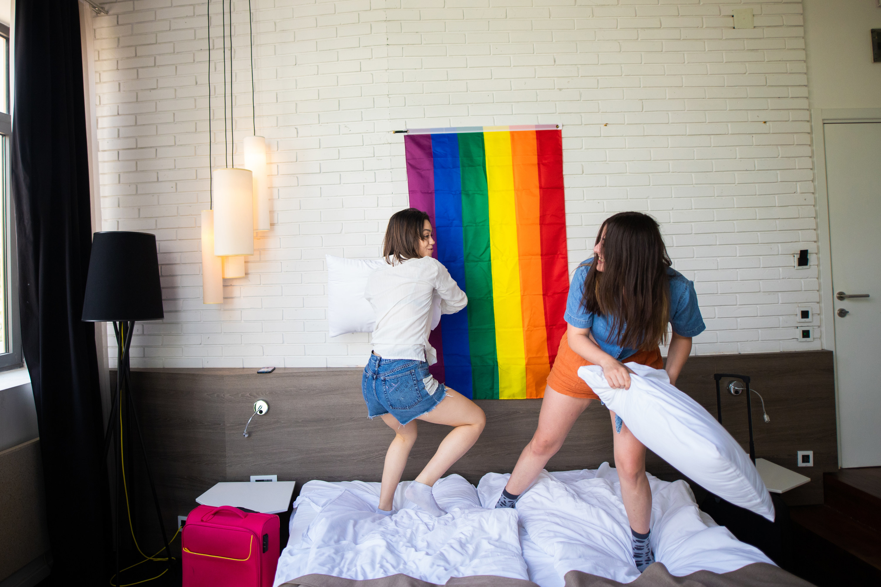 Two girls having pillow fight in hotel room