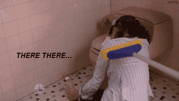 Gif from 30 Rock of a character passed out on a toilet, with someone half-heartedly comforting her by petting her with a broom and saying