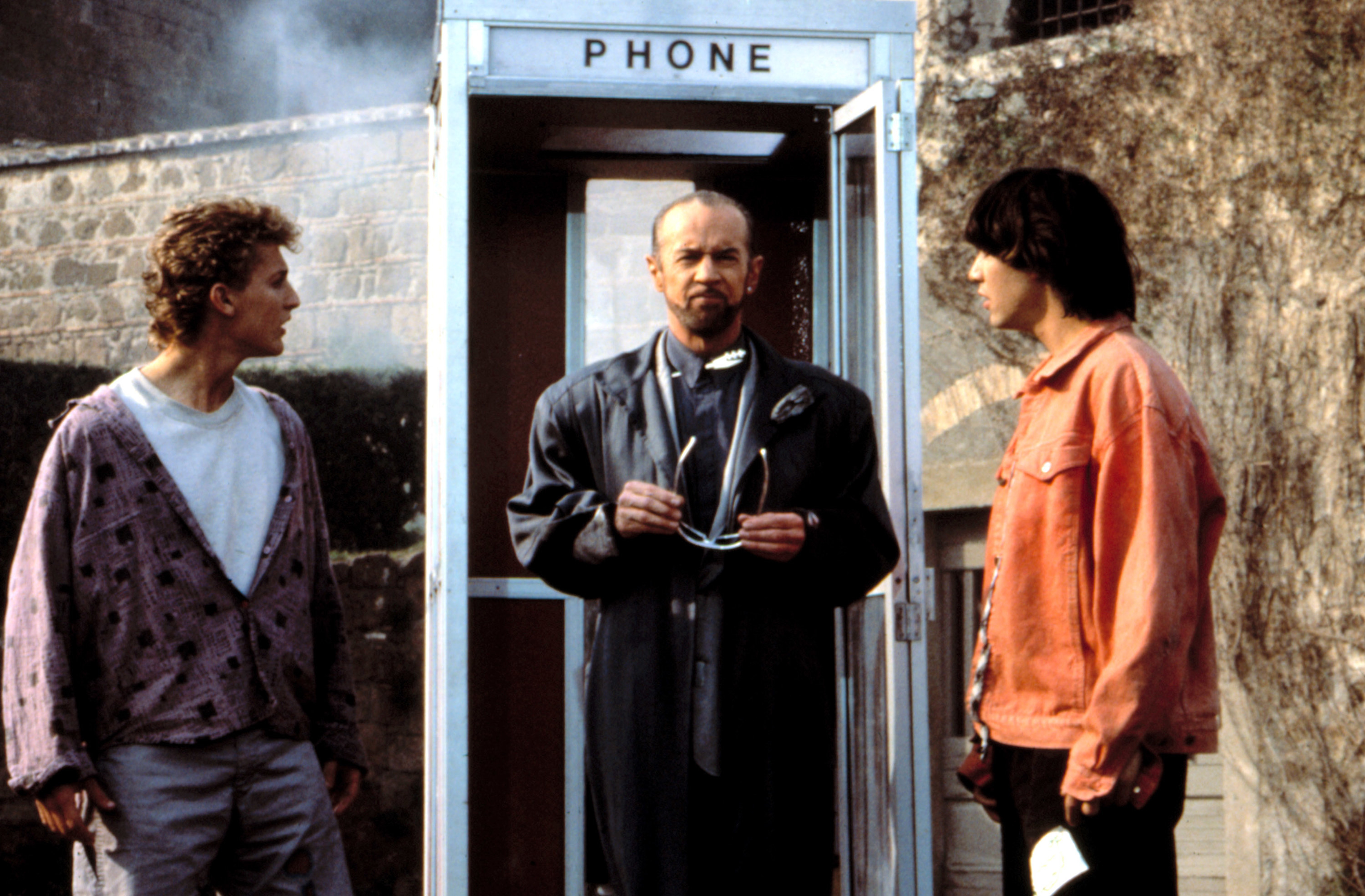 Keanu looks at George who is standing in a phone booth in the movie