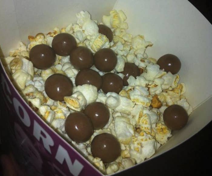 A close up of popcorn that has been mixed with Maltesers