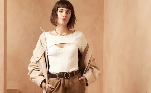 Model wearing white top with brown pants and brown jacket