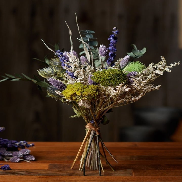 a small dried bouquet of purple and green flowers