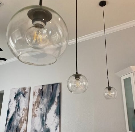A reviewer&#x27;s image of a single globe pendant light inside a room