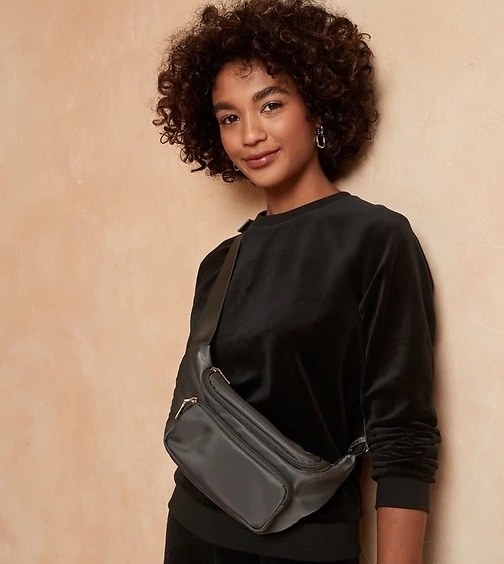 Model wearing black top with black bag and black pants