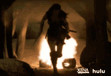 Lucy Lawless as Xena runs away from fire in &quot;Xena: Warrior Princess&quot;