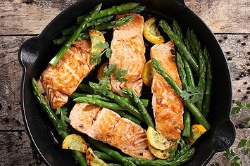 Salmon and asparagus in the skillet with our spouts and a helper handle
