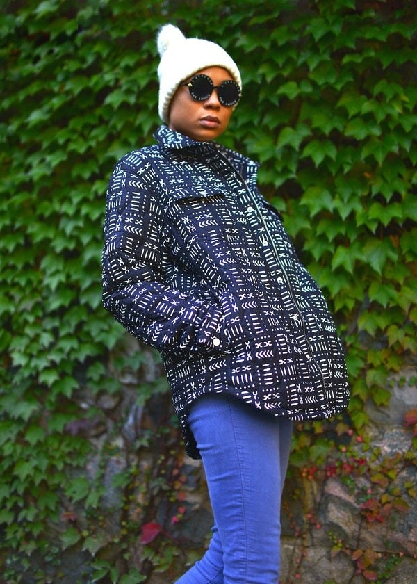 a model in a quilted jacket that is black with tiny white designs on it