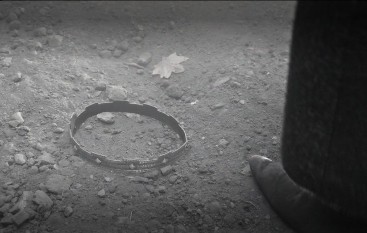 Macbeth&#x27;s crown lying on the dirt with someone&#x27;s foot standing next to it in &quot;The Tragedy of Macbeth&quot; (2021)