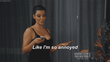 Kim Kardashian looking at her phone and saying