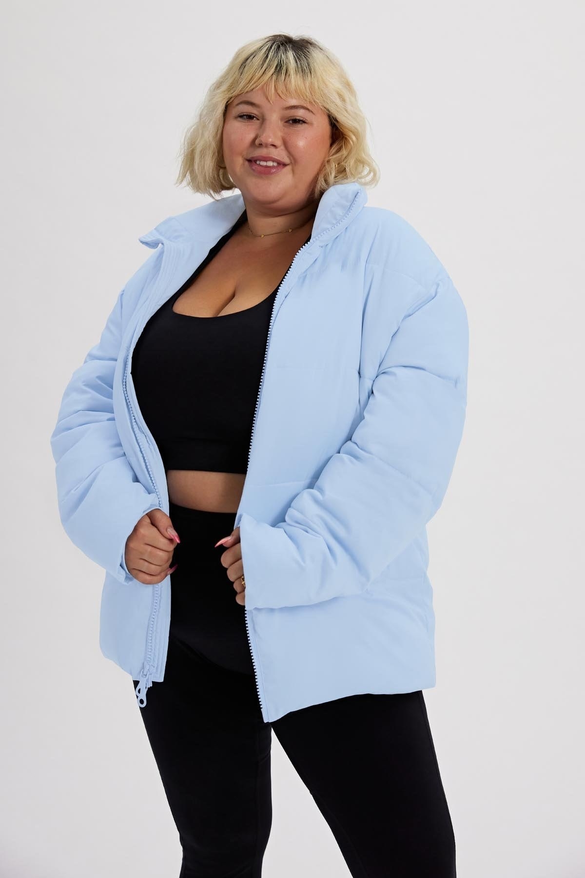a model in a light blue puffer coat