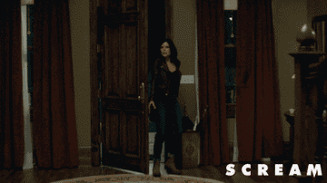 Sidney Prescott entering a house with a gun