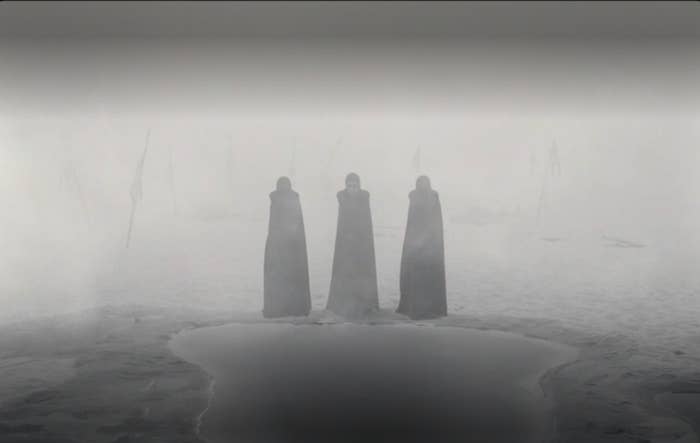 The Three Witches standing in front of a puddle of water in "The Tragedy of Macbeth" (2021)