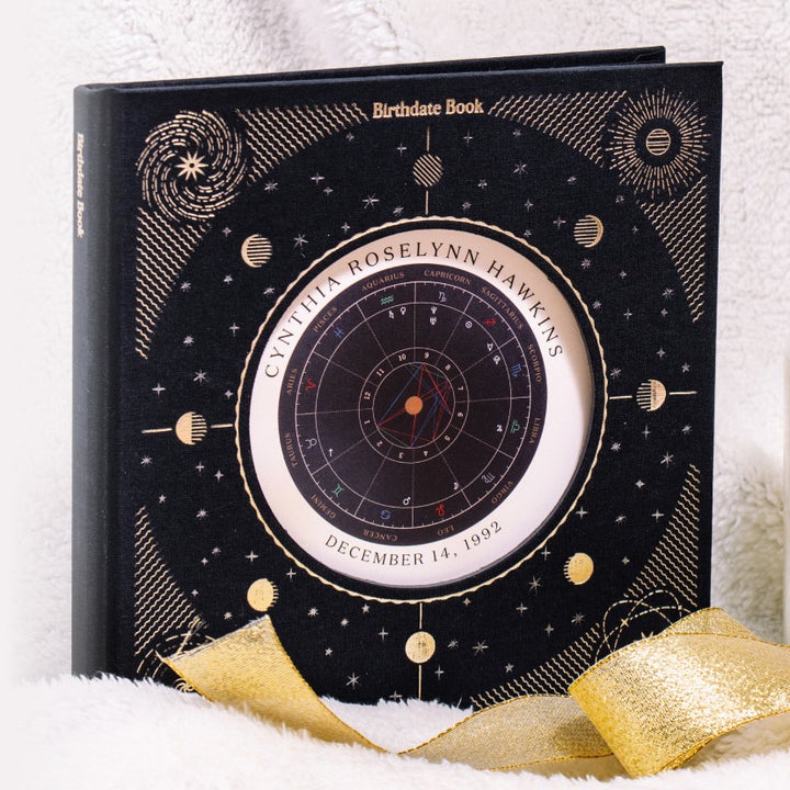 a black book with gold designers and a circular birth chart in the middle
