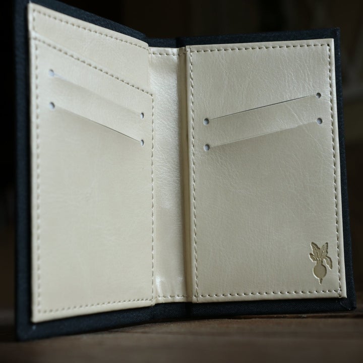 the open wallet with four card slots, a slip pocket, and a small embossed beet in the lower right corner