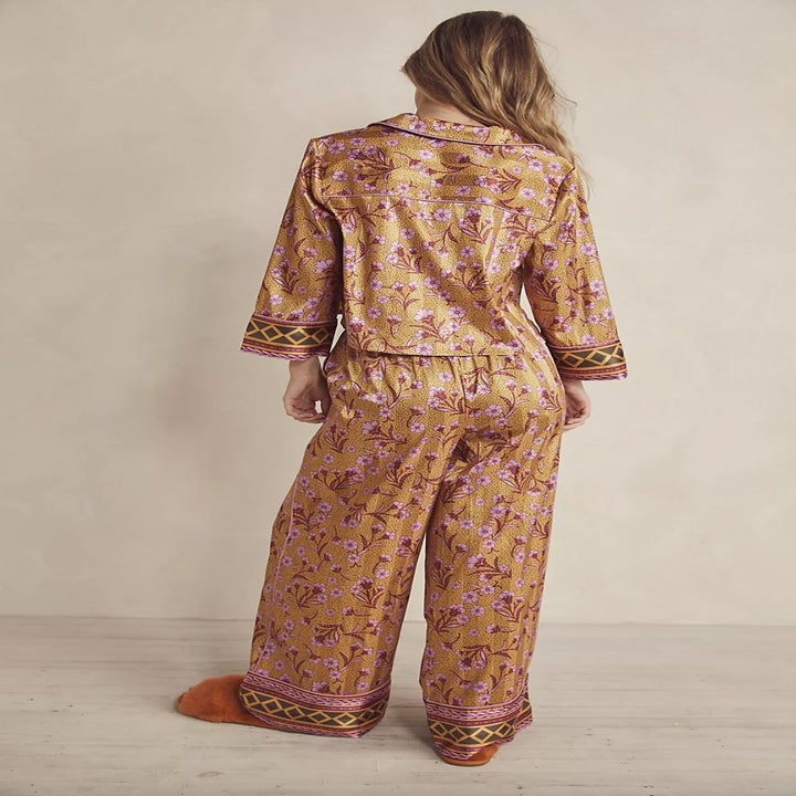 model wearing gold and pink flower pajamas