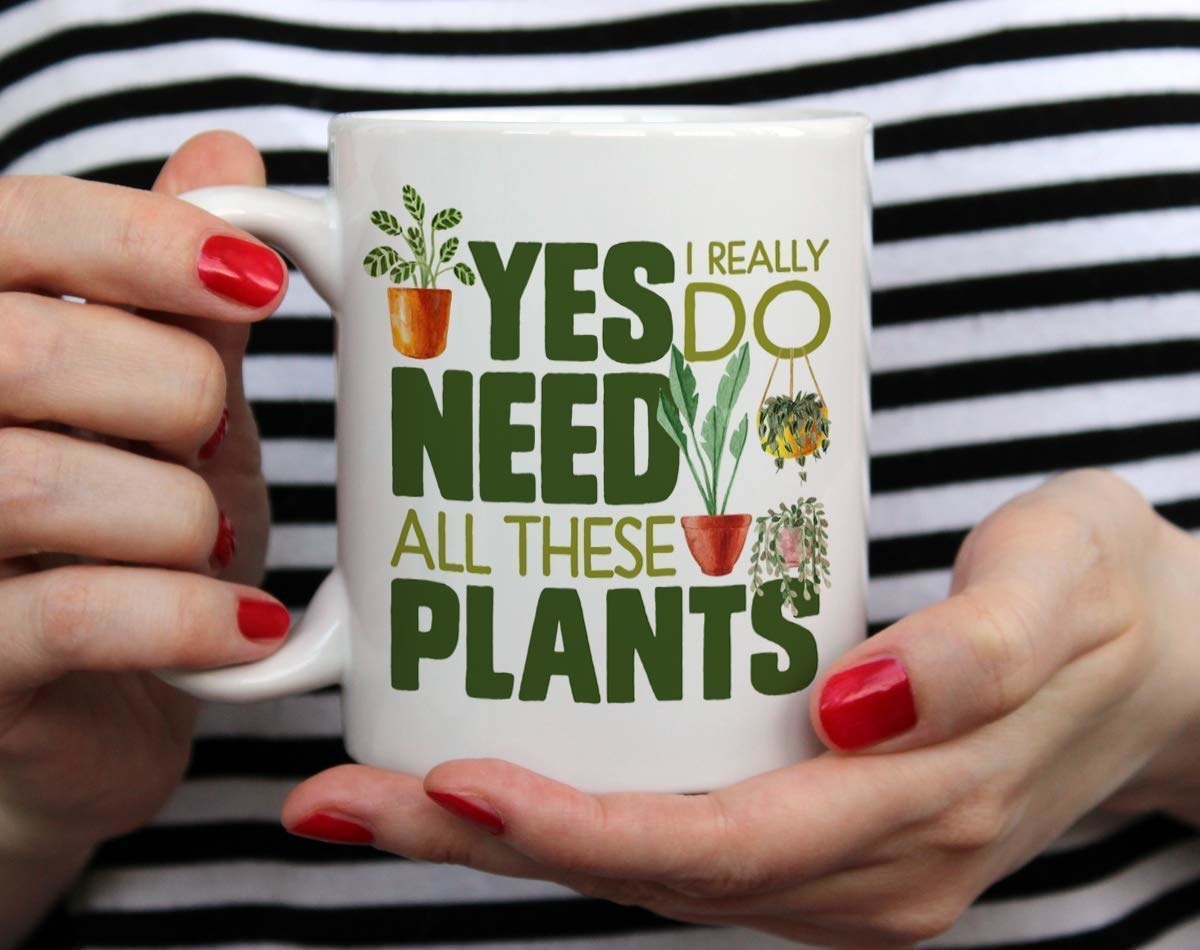 close up of someone holding the mug that says: yes i really do need all these plants