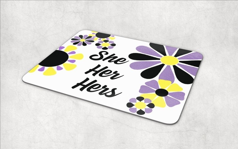 the yellow, white, purple, and black mouse pad with she, her, hers pronouns in the center
