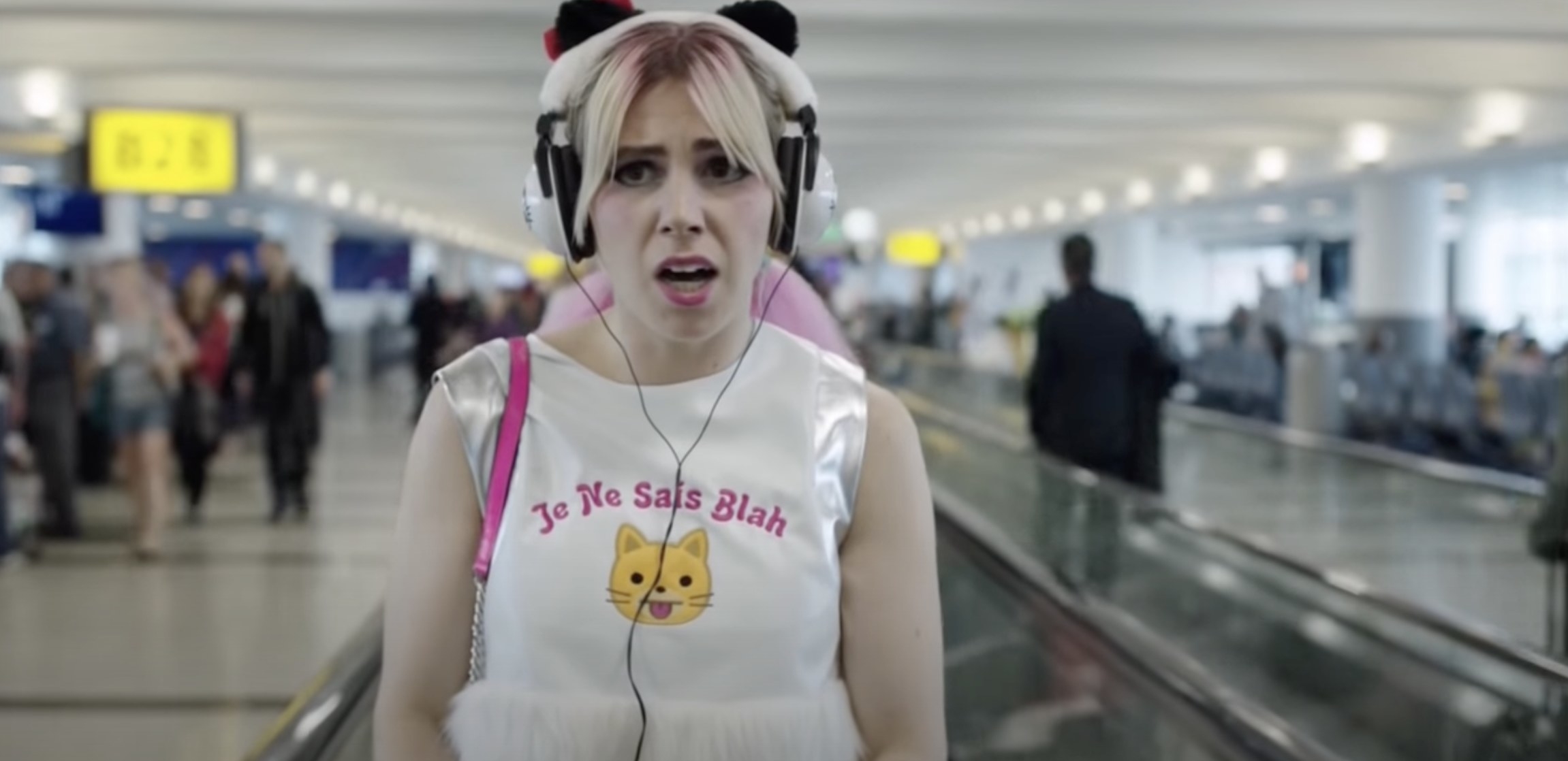 Shoshanna rides a conveyor belt at airport