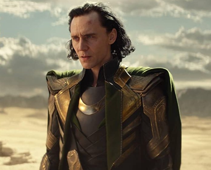 loki has chin-length hair that&#x27;s pushed back, wears a shiny suit and cape