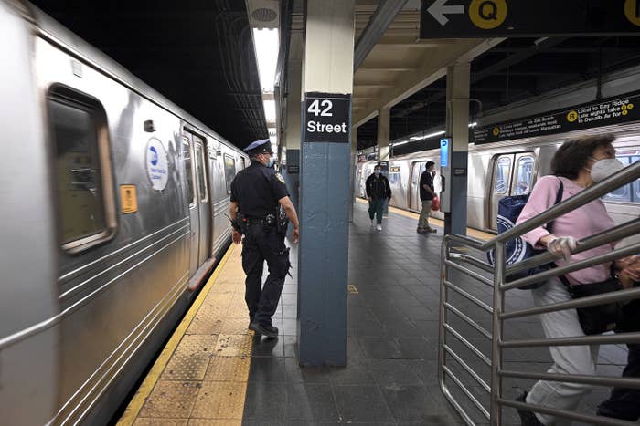 A police officer stands on the platform at the 42nd Street subway station