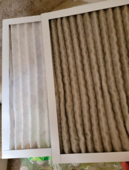 a reviewer&#x27;s photo of the new clean furnace filter next to a dirty old filter