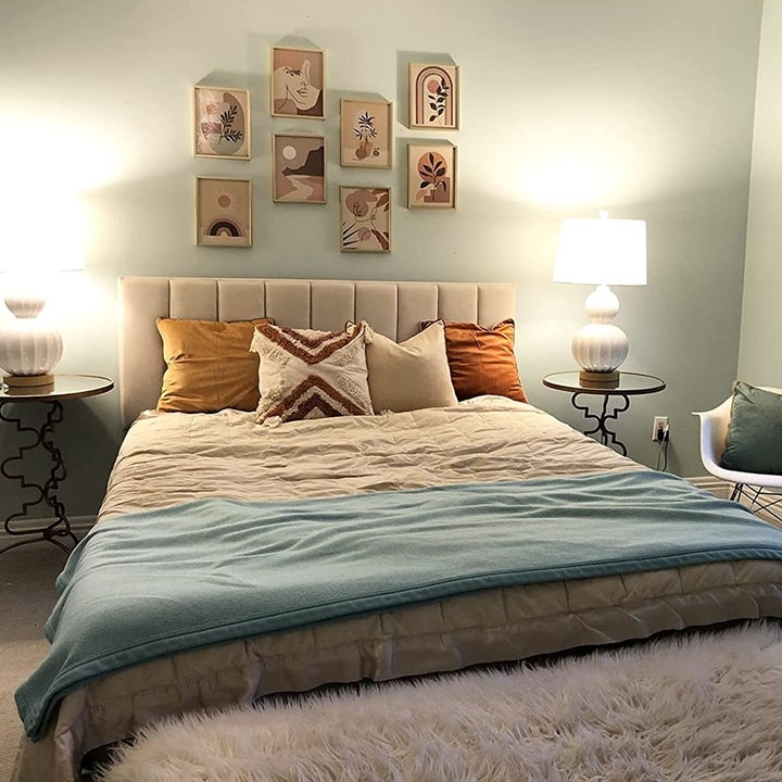 reviewer photo of the set of wall art hanging above a bed