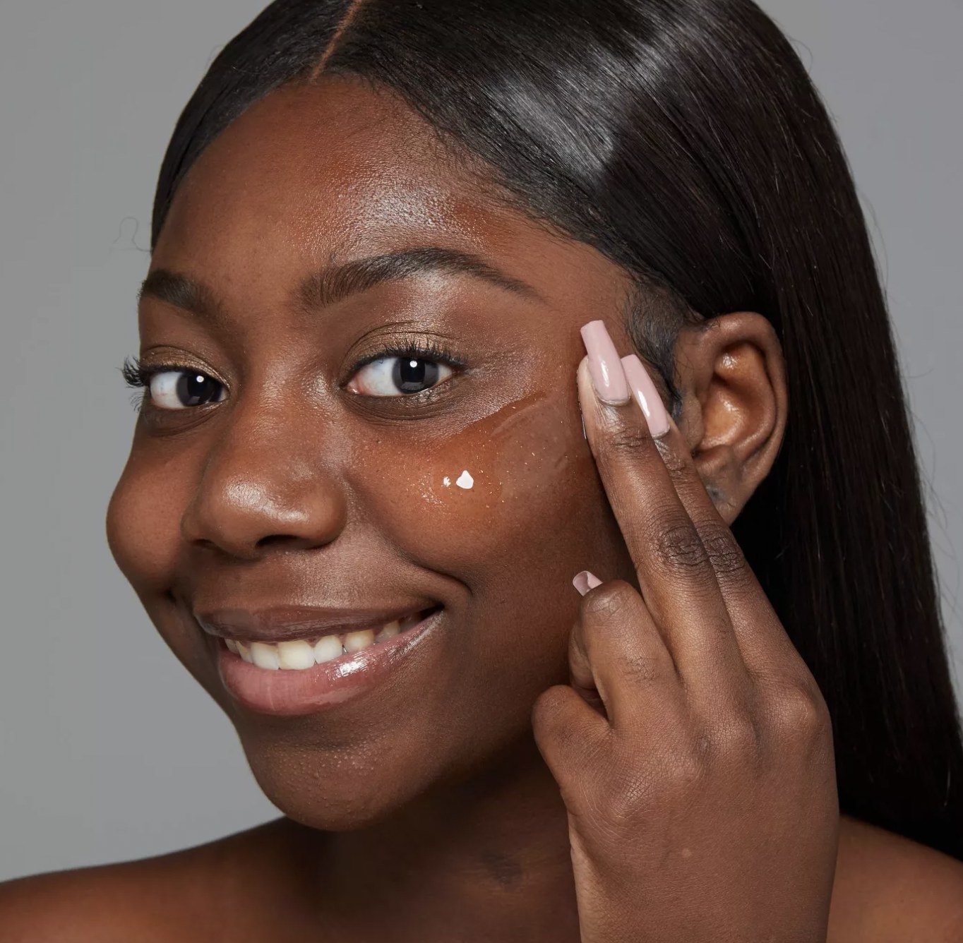 A person applying primer to their skin