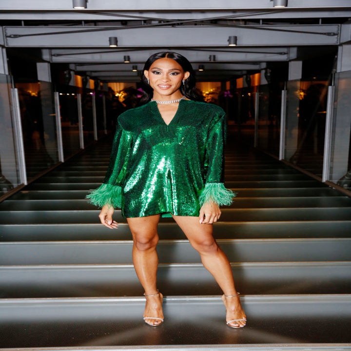 Mj stuns as she poses for the camera in strappy heels and a sequined long-sleeve and fringe-lined mini dress