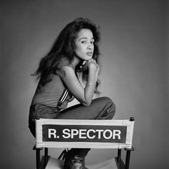 Shot of Ronnie as she sits on a director's chair with the wording "R SPECTOR" in all caps