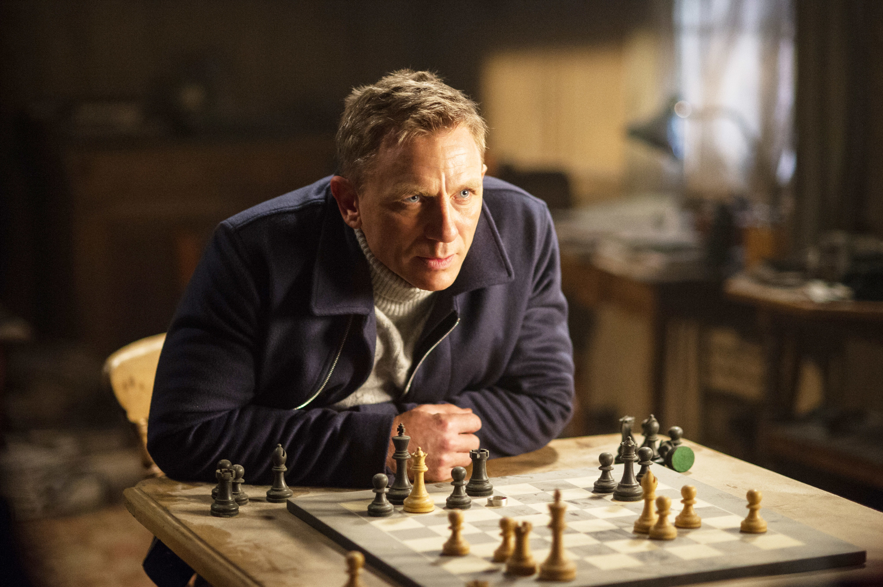 Daniel Craig sitting at a table with a chess board