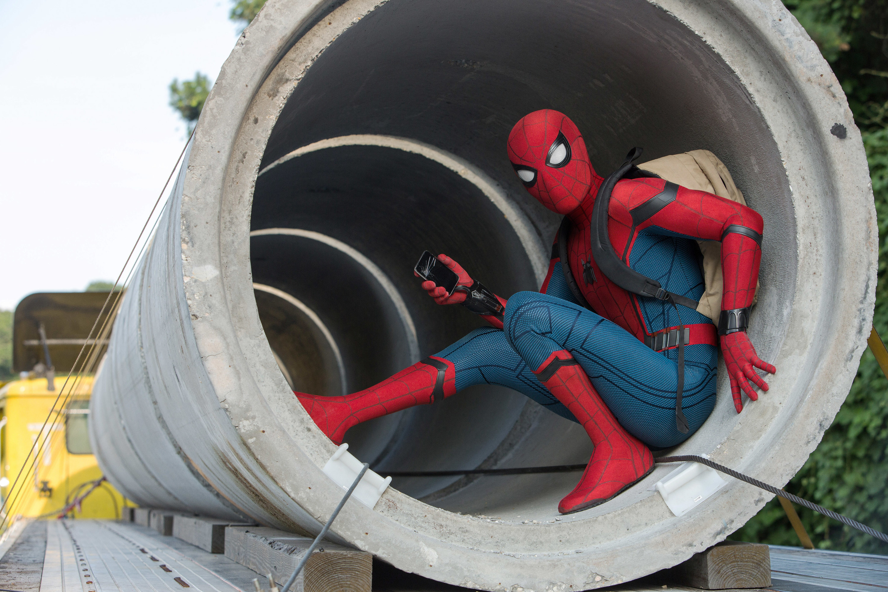 Spider-Man sitting in a cement cylinder