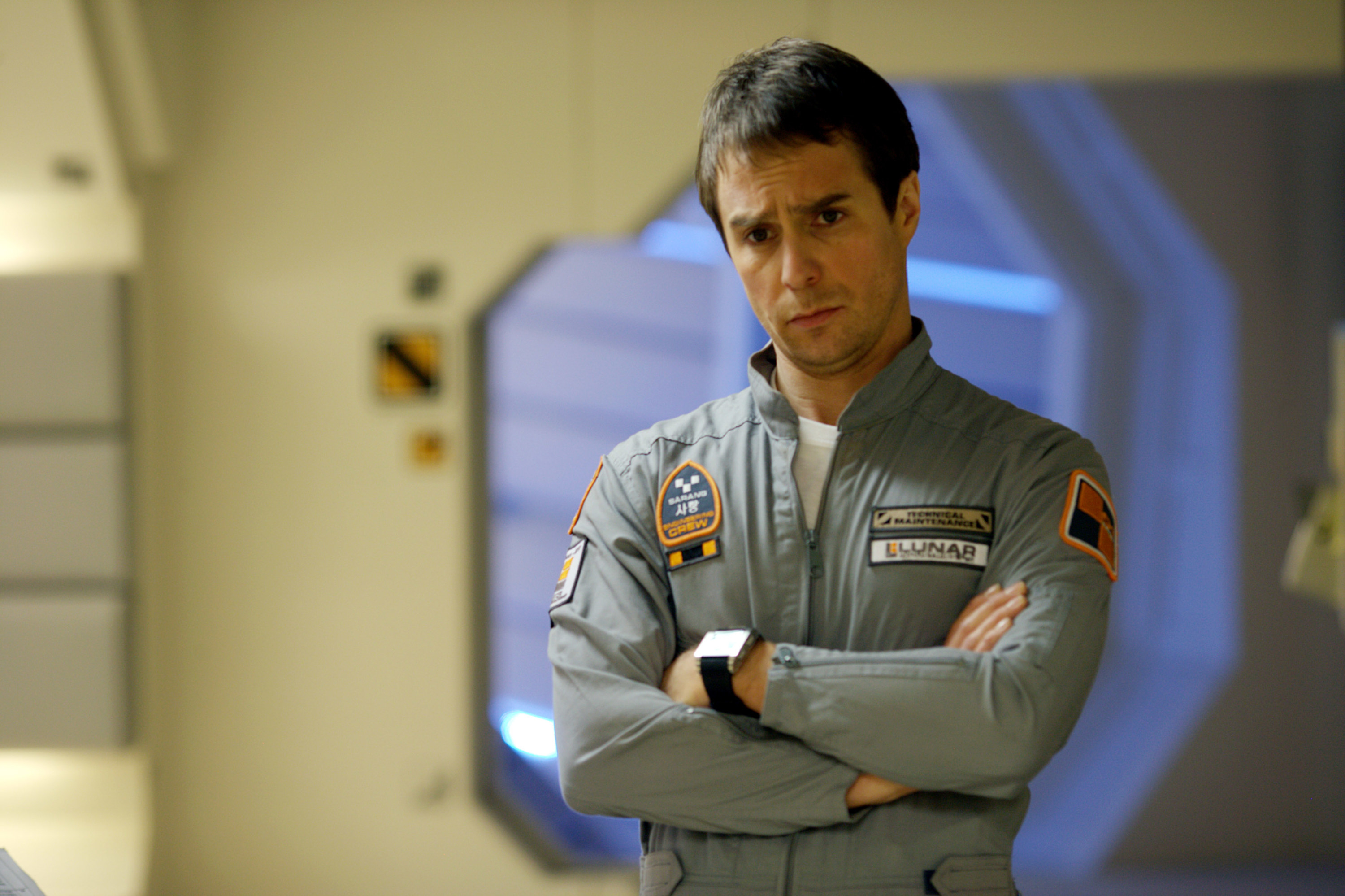 Sam Rockwell standing in a spaceship with his arms crossed