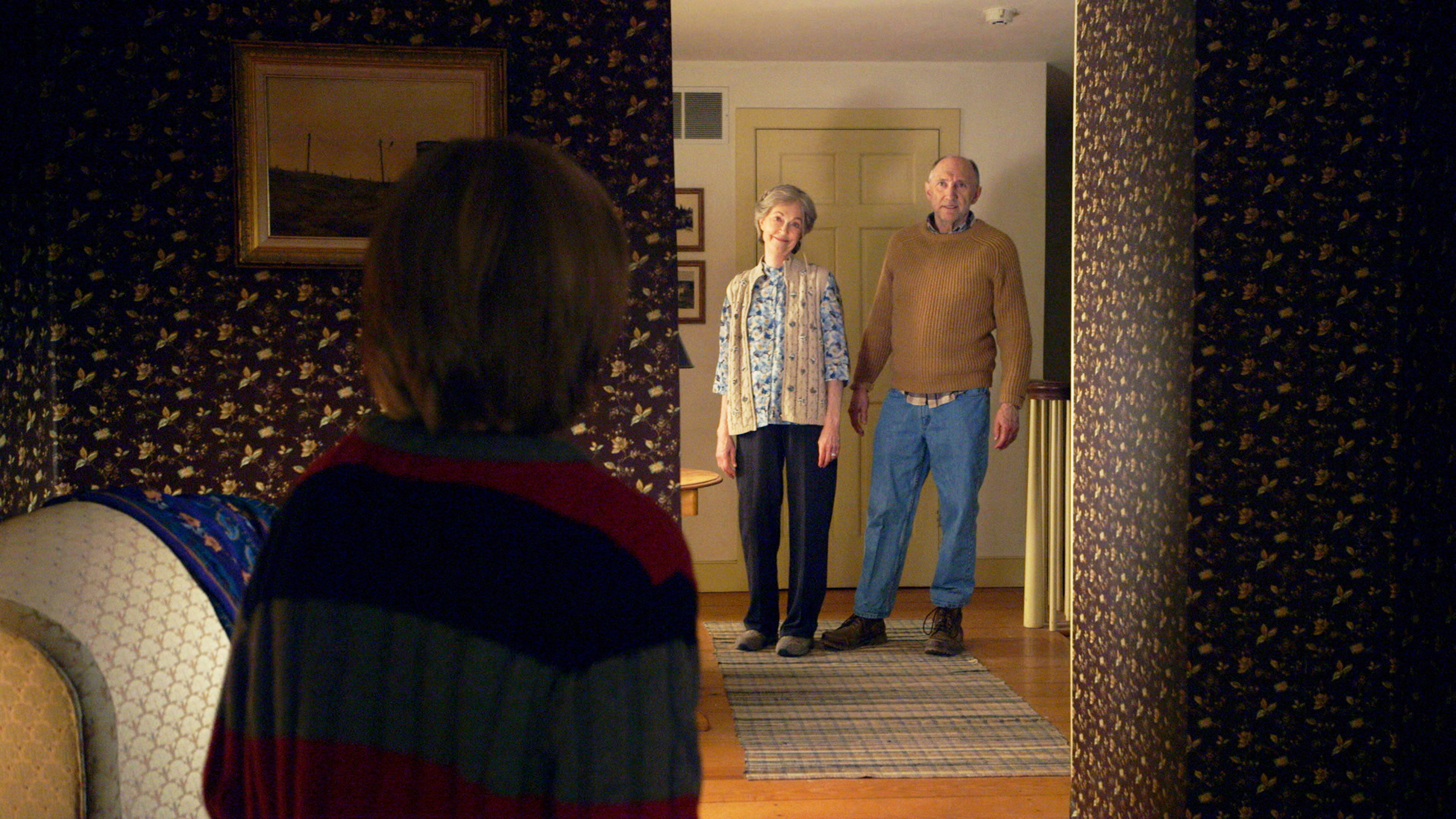 Two older people looking a child in its room