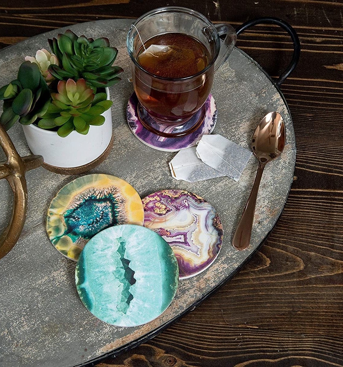 a set of four gemstone coasters on a coffee table