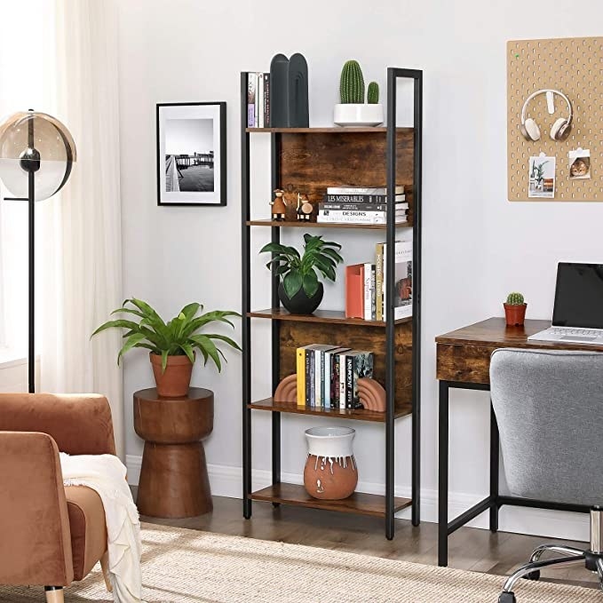 An industrial book shelf with books and plants on it in a living room